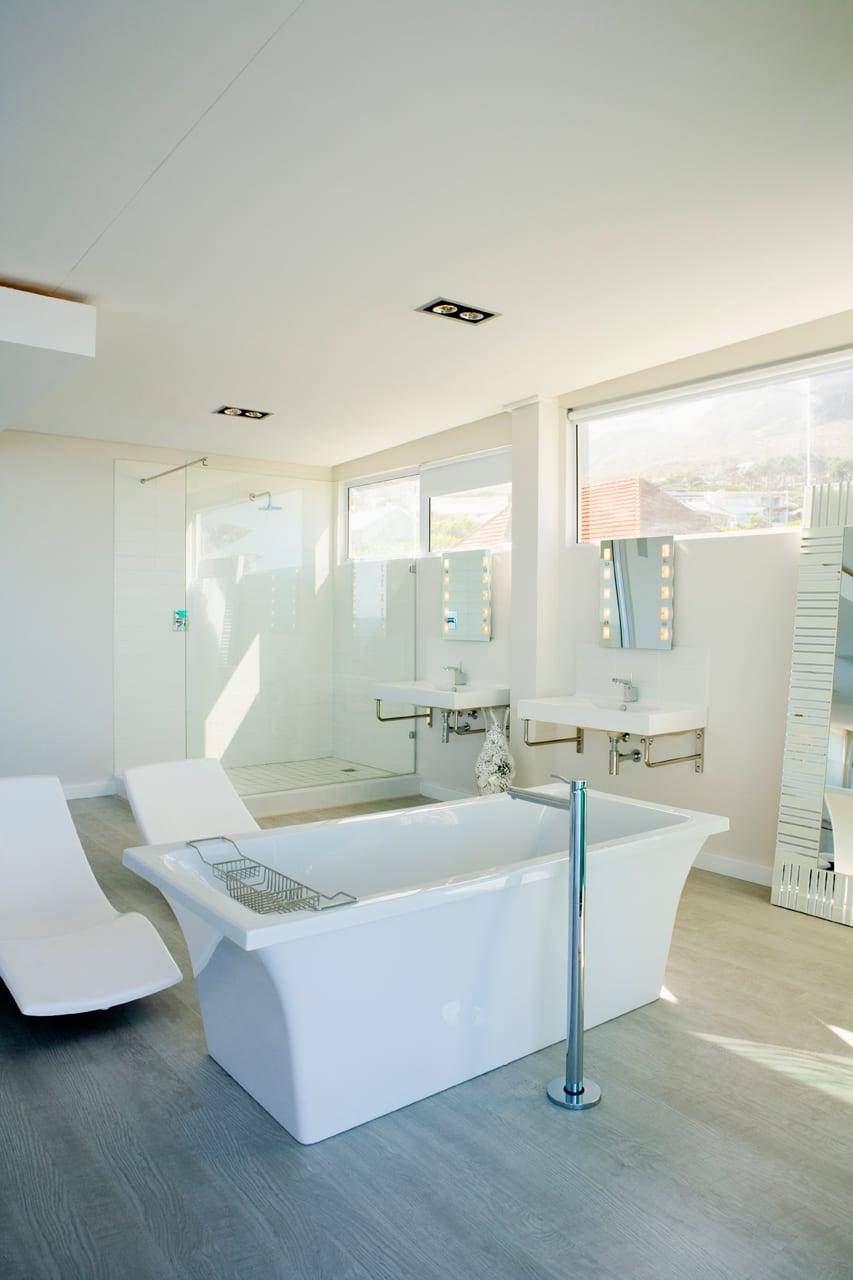 Helles Badezimmer mit freistehender Wanne, zwei Waschbecken und bodentiefen Fenstern
